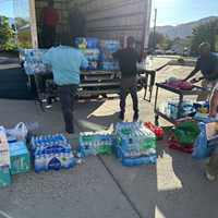 employees and volunteers loading a truck with supplies for those affected by fire and flood 